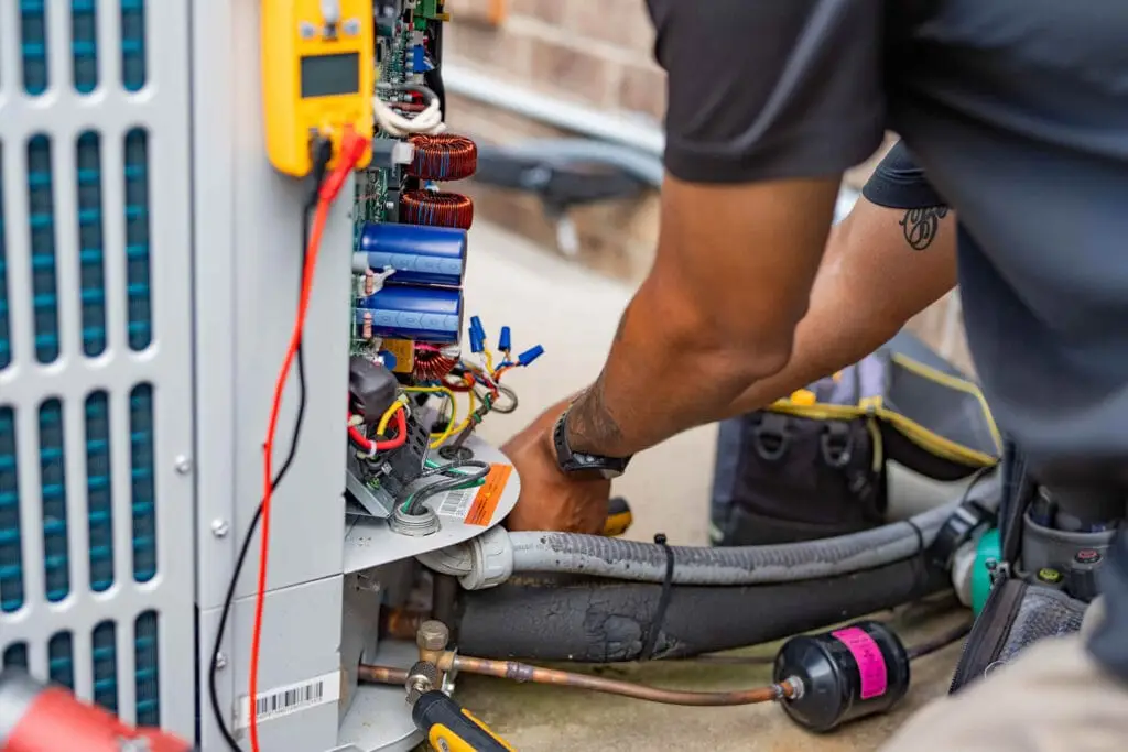 Close-up of Airstream Services HVAC technician servicing electrical and refrigerant lines on an outdoor air conditioning unit in Middle Tennessee.