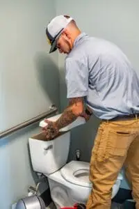 Airstream Services plumber inspecting the tank of a residential toilet during a plumbing and drain cleaning service in Middle Tennessee.