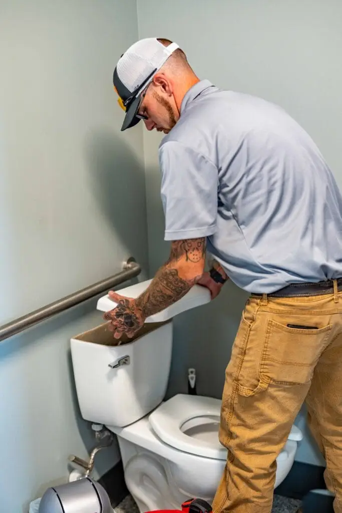 Airstream Services plumber inspecting the tank of a residential toilet during a plumbing and drain cleaning service in Middle Tennessee.