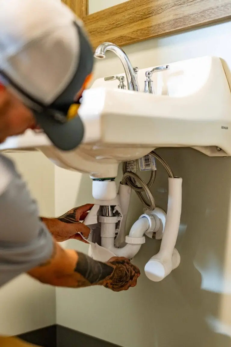 Airstream Services plumber removing the P-trap from a bathroom sink to clear a clogged drain in a Middle Tennessee home.
