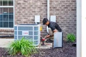 HVAC technician from Airstream Services performing maintenance on a ductless mini-split outdoor unit at a residential property in Middle Tennessee.