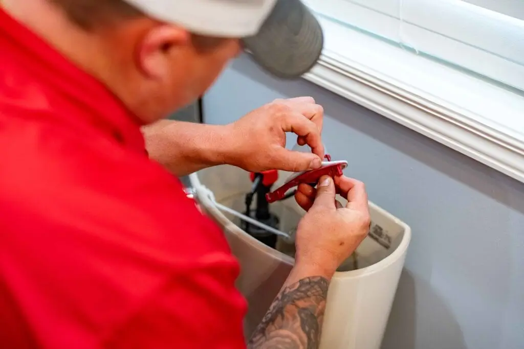 Airstream employee doing maintenance on a toilet.