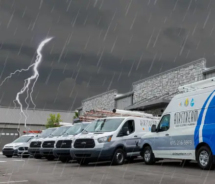 Airstream Services electrical vans parked during a thunderstorm with visible lightning in the sky, symbolizing the importance of surge protection during storm season.