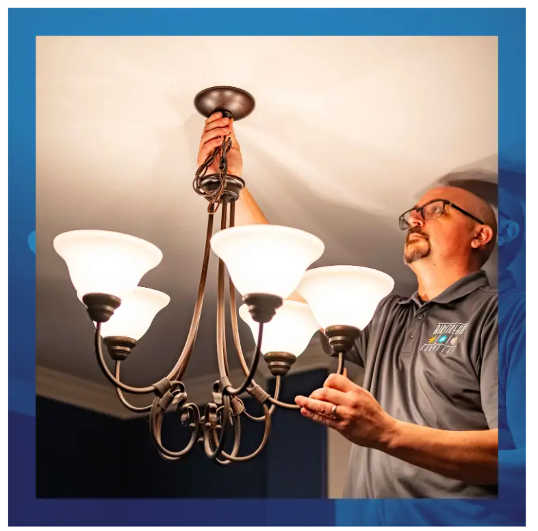 Electrician installing or repairing a chandelier in a home.