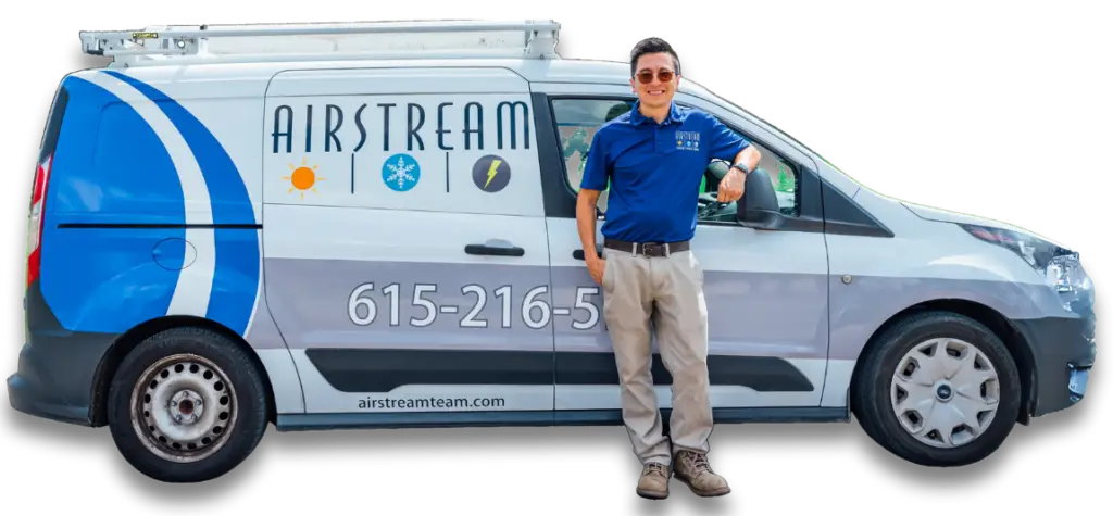 Airstream Plumbing, Heating & Air technician standing proudly next to a branded service van.