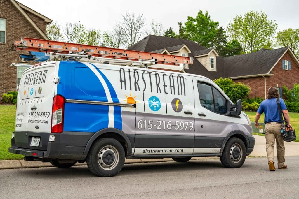 Airstream Services electrician van parked in a Smyrna, TN neighborhood with a technician walking toward a home.